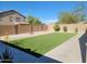 Spacious backyard featuring artificial turf, desert landscaping, and a concrete patio, perfect for outdoor living at 36114 W Vera Cruz Dr, Maricopa, AZ 85138