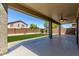 Covered patio with a lush green lawn and block fence for privacy at 36114 W Vera Cruz Dr, Maricopa, AZ 85138