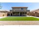 Large backyard featuring gravel, synthetic lawn, and covered patio attached to a two-story home at 36114 W Vera Cruz Dr, Maricopa, AZ 85138