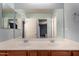 Bright bathroom featuring double sinks, neutral paint, and a large mirror perfect for getting ready at 36114 W Vera Cruz Dr, Maricopa, AZ 85138