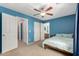 Comfortable bedroom with large bed, wood ceiling fan and a view into the ensuite bathroom at 36114 W Vera Cruz Dr, Maricopa, AZ 85138
