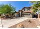 Attractive home exterior with a two-car garage, desert landscaping, and a well-maintained front yard at 36114 W Vera Cruz Dr, Maricopa, AZ 85138