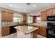 Stylish kitchen with island, granite countertops, neutral paint, and modern appliances at 36114 W Vera Cruz Dr, Maricopa, AZ 85138