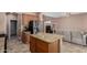 Kitchen island with granite countertops and stainless steel appliances next to a living area at 36114 W Vera Cruz Dr, Maricopa, AZ 85138