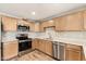 Updated kitchen features stainless steel appliances, wood cabinets, and quartz countertops at 3624 E Hearn Rd, Phoenix, AZ 85032