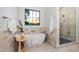 Modern bathroom features a soaking tub under a window and a glass-enclosed shower at 4107 E Edgemont Ave, Phoenix, AZ 85008
