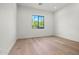 Bright, minimalist bedroom with wood floors and a large window offering scenic outdoor views at 4107 E Edgemont Ave, Phoenix, AZ 85008