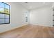 Bright, empty bedroom with hardwood floors and a large window offering lots of light at 4107 E Edgemont Ave, Phoenix, AZ 85008