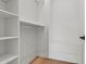 A white walk in closet with wood floor features shelving for storage at 4107 E Edgemont Ave, Phoenix, AZ 85008