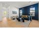 Chic living room with hardwood floors, a stylish navy accent wall and abundant natural light at 4107 E Edgemont Ave, Phoenix, AZ 85008