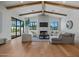 Open-plan living room features hardwood floors, vaulted ceilings, and fireplace at 4107 E Edgemont Ave, Phoenix, AZ 85008
