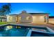 Backyard pool with an attached spa, set against the backdrop of a modern home and twilight sky at 4107 E Edgemont Ave, Phoenix, AZ 85008