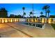 Backyard featuring a pool with a spa, palm trees, and ambient lighting for evening relaxation at 4107 E Edgemont Ave, Phoenix, AZ 85008
