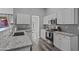 Well-lit kitchen with modern appliances, gray countertops, white cabinets, and wood-look floors at 418 W Sagebrush St, Gilbert, AZ 85233