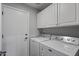 Functional laundry room with modern washer, dryer, and ample cabinet storage at 418 W Sagebrush St, Gilbert, AZ 85233