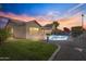 Evening view of backyard featuring a sparkling pool and well-manicured landscaping at 418 W Sagebrush St, Gilbert, AZ 85233