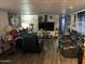 Living room with dark leather furniture, sleek flooring, and bright lighting at 4211 W Roosevelt St # 235, Phoenix, AZ 85009
