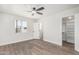 Bright bedroom showcasing wood-look floors, a ceiling fan, and walk-in closet access at 4531 N 12Th Dr, Phoenix, AZ 85013