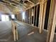 Unfinished interior view showing the framework of the home with studs, electrical wiring, and a concrete floor at 47720 W Kenner Dr, Maricopa, AZ 85139