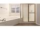 A bathroom featuring a soaking tub, glass enclosed shower and shuttered windows at 492 E Vermont Dr, Gilbert, AZ 85295