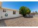 Gravel backyard with window view of house, mature shade tree, and tidy perimeter wall at 5122 E Emerald Cir, Mesa, AZ 85206