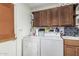 Functional laundry room with upper cabinets, washer, dryer, and adjacent folding counter at 5122 E Emerald Cir, Mesa, AZ 85206