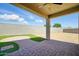 This backyard features a covered patio with brick pavers and artifical turf at 5956 N 188Th Ln, Litchfield Park, AZ 85340
