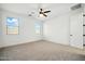 Spacious bedroom features neutral carpeting, a ceiling fan, and two windows at 5956 N 188Th Ln, Litchfield Park, AZ 85340