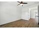 A bright bedroom with wood flooring, ceiling fan and views into the hallway at 5956 N 188Th Ln, Litchfield Park, AZ 85340