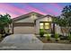 Charming single-story home with a well-maintained lawn and a two-car garage, all under a beautiful sunset sky at 5956 N 188Th Ln, Litchfield Park, AZ 85340
