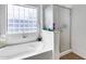 Bright bathroom featuring a bathtub and a glass block window at 6328 W Fawn Dr, Laveen, AZ 85339