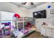 Bright ' bedroom with bunk beds, a TV, and a white dresser at 6328 W Fawn Dr, Laveen, AZ 85339