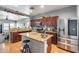 Modern kitchen with stainless steel appliances, granite countertops, and cherry wood cabinets at 6328 W Fawn Dr, Laveen, AZ 85339