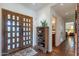 Welcoming foyer featuring tiled floors, decorative doors, and an elegant wooden shelving unit at 6418 E Sunnyside Dr, Scottsdale, AZ 85254
