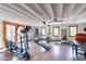 Bright home gym with wood floors, ceiling beams, and a variety of fitness equipment at 6418 E Sunnyside Dr, Scottsdale, AZ 85254