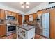 Traditional kitchen featuring stainless steel appliances, a center island, and terra cotta tile floors at 6418 E Sunnyside Dr, Scottsdale, AZ 85254