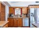 A well-lit kitchen features wood cabinets, stainless steel appliances, and terracotta tiled flooring at 6418 E Sunnyside Dr, Scottsdale, AZ 85254