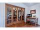 Cozy office space with a desk setup, complemented by rich hardwood floors and sliding glass doors at 6418 E Sunnyside Dr, Scottsdale, AZ 85254