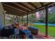 Covered patio with comfortable seating, fire pit, and a view of the inviting pool and garden at dusk at 6418 E Sunnyside Dr, Scottsdale, AZ 85254