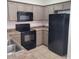 Functional kitchen with ample cabinets, black appliances, and tile flooring at 6908 S 8Th Dr, Phoenix, AZ 85041