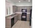 Well-equipped kitchen with black appliances, tile floors, and tan cabinets at 6908 S 8Th Dr, Phoenix, AZ 85041