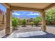 Charming covered patio with stone pillars framing a tranquil backyard featuring desert landscaping and a low brick fence at 6941 E Snowdon St, Mesa, AZ 85207