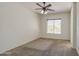 Large bedroom with a window, neutral carpet, ceiling fan, and light walls at 6941 E Snowdon St, Mesa, AZ 85207