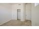 Bedroom featuring neutral carpet, white walls, a standard door and closet with sliding doors, great for storage at 6941 E Snowdon St, Mesa, AZ 85207