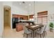 Well-lit kitchen and dining area with stainless steel appliances, an island, and a dining table for six at 6941 E Snowdon St, Mesa, AZ 85207