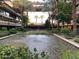 A beautiful pond with fountains, landscaping, and chairs is surrounded by an open-air building at 7157 E Rancho Vista Dr # 1004, Scottsdale, AZ 85251