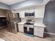 Renovated kitchen features modern stainless steel appliances and white cabinets at 7903 N 61St Ave, Glendale, AZ 85301