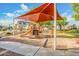 Community playground with a large sunshade structure, slide, and other play equipment on a sand base for safe play at 8113 W Groom Creek Rd, Phoenix, AZ 85043