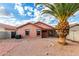 The backyard features gravel, a palm tree, a block fence, and a covered patio at 8433 E Natal Cir, Mesa, AZ 85209
