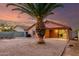 This backyard features gravel, a palm tree, a block fence and a covered patio at 8433 E Natal Cir, Mesa, AZ 85209